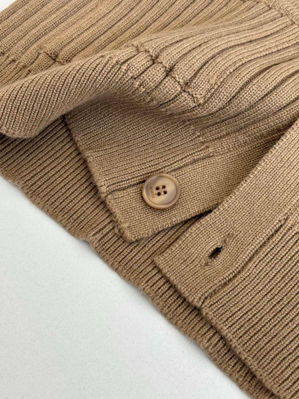Tan knit cardigan pocket and round button detail on ribbed fabric