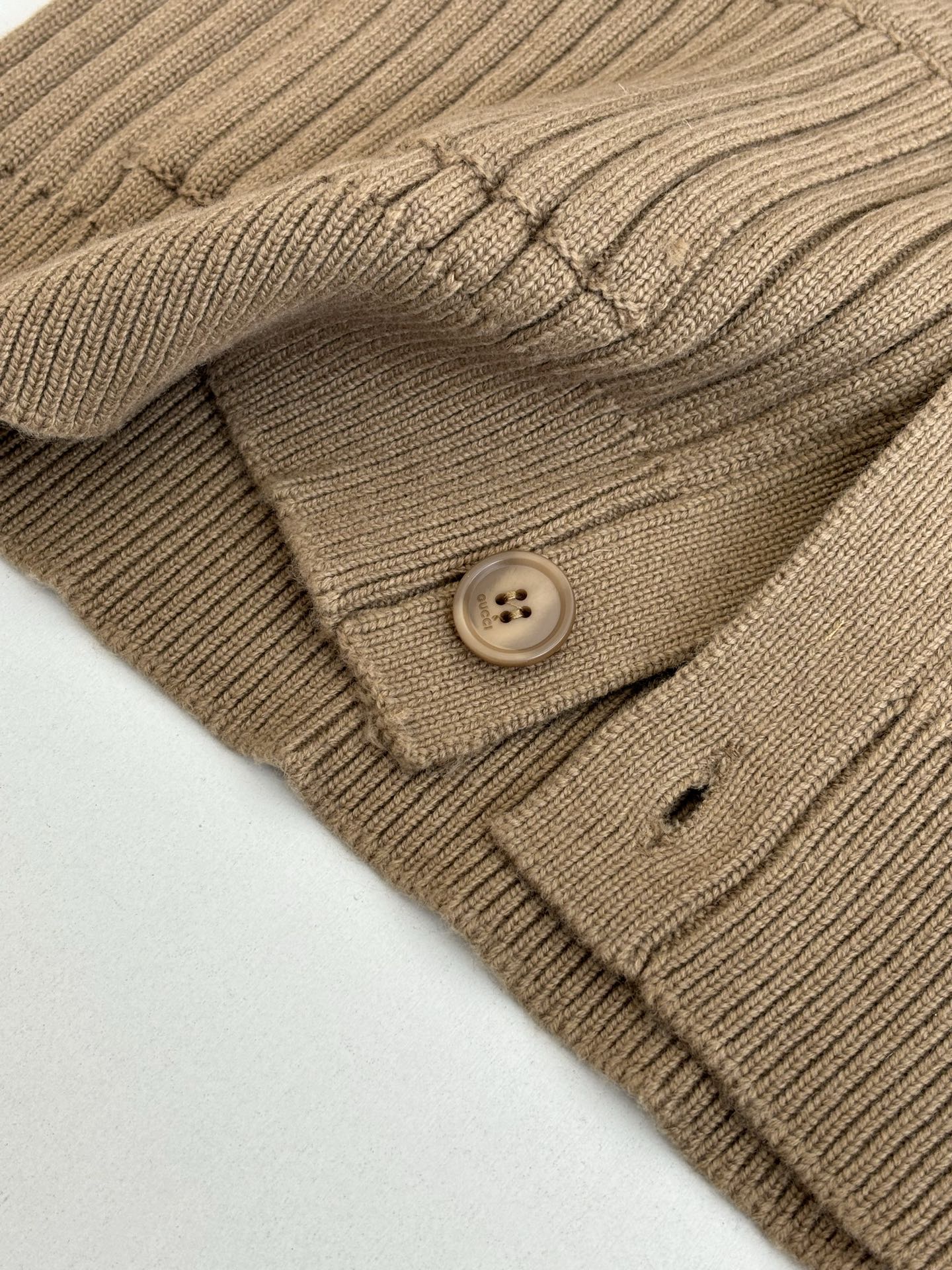 Tan knit cardigan pocket and round button detail on ribbed fabric