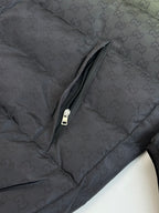 Dark monogram puffer jacket sleeve panel with zipper seam and pull tab