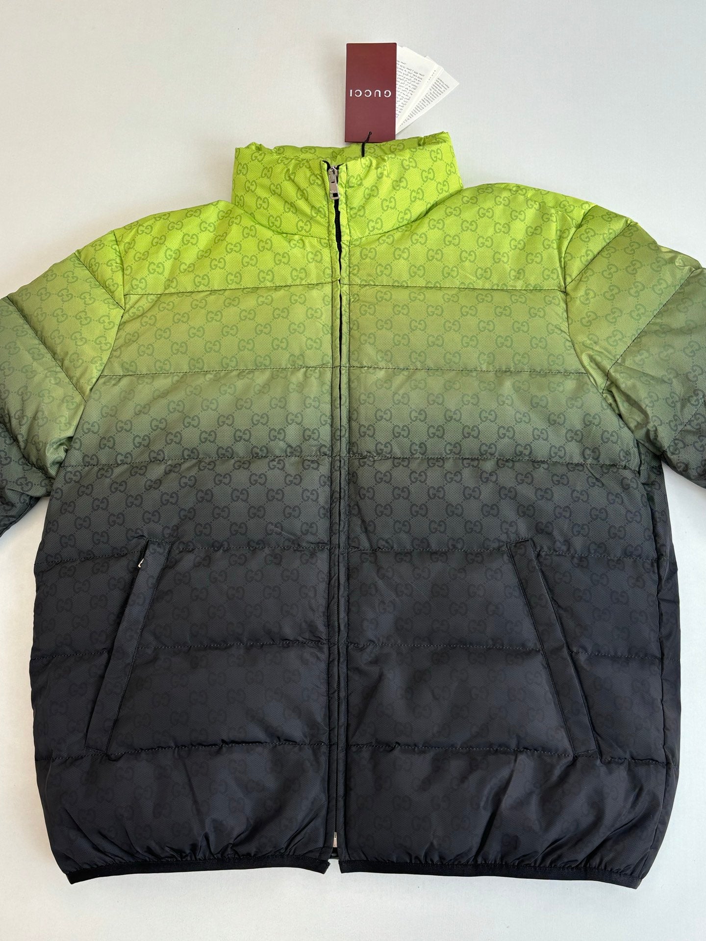 Color-block puffer jacket on hanger, lime green top and dark bottom, full-zip