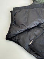 Folded dark puffer jacket with black zipper and quilted interior lining