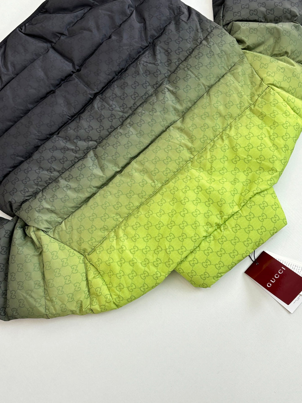 Folded puffer jacket set: lime green top layer and dark layer with monogram