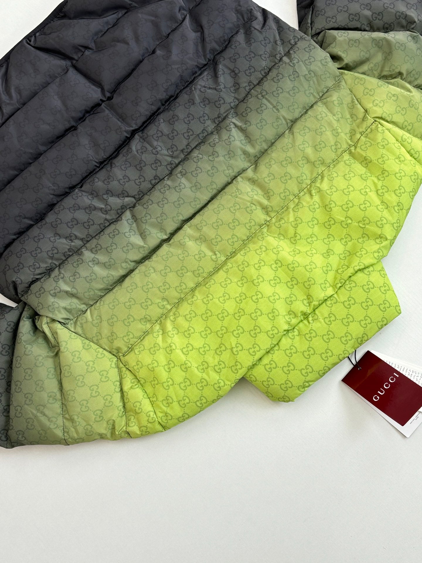 Folded puffer jacket set: lime green top layer and dark layer with monogram