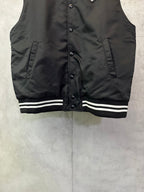 Sleeveless dark bomber vest with snap buttons and striped ribbed hem