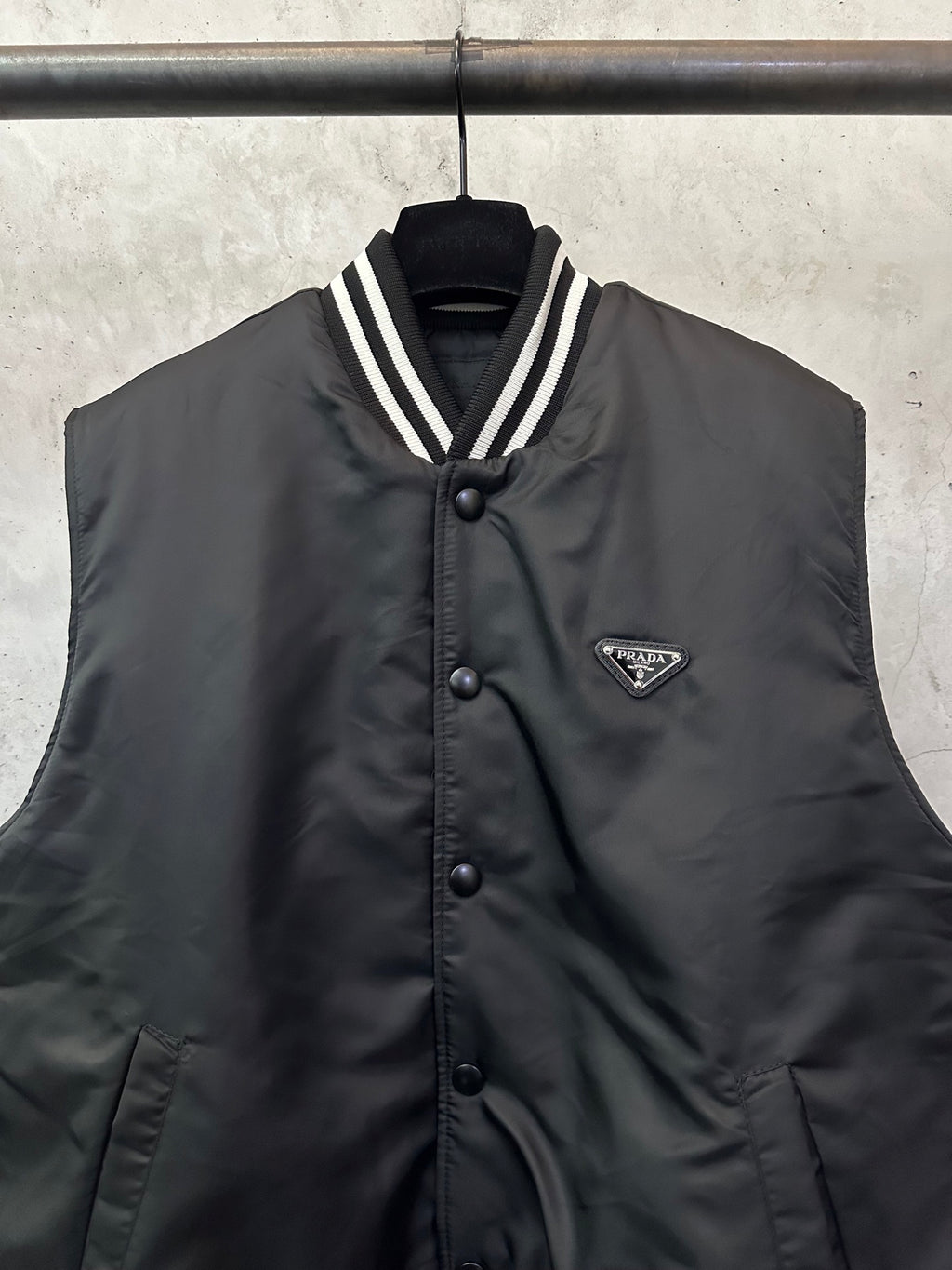 Sleeveless dark bomber vest with button placket and Prada triangular logo