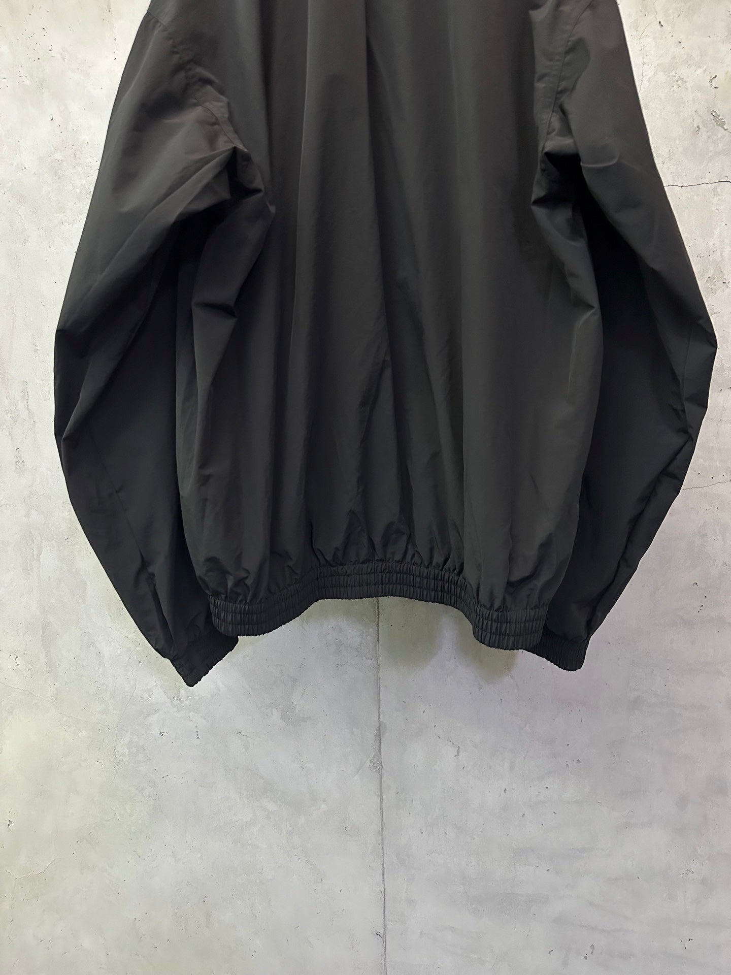Black long bomber jacket, back view, gathered elastic hem and cuffs