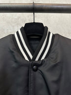 Sleeveless dark bomber vest with striped V-collar and black button