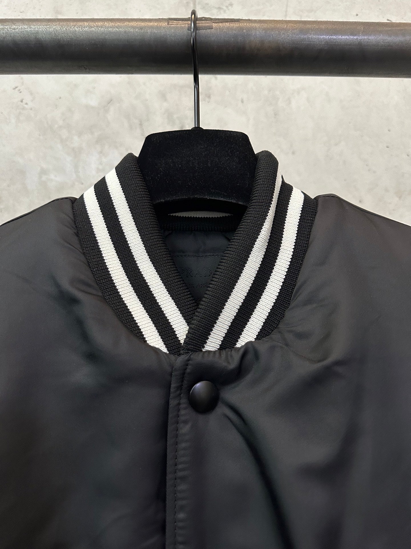 Sleeveless dark bomber vest with striped V-collar and black button