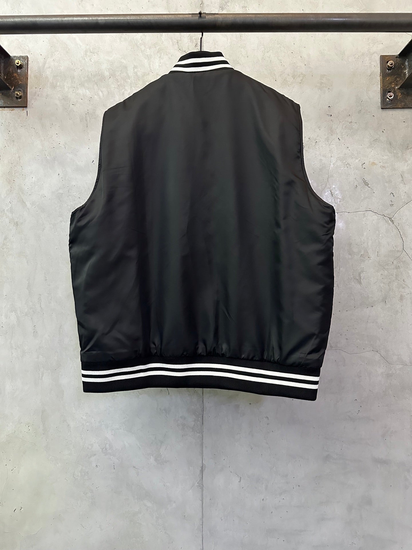 Sleeveless dark bomber vest with striped hem and ribbed cuffs