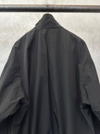 Black long bomber jacket, high collar/hood shape, pleated back