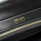 Prada Made in Italy leather label on black bag with gold zipper detail.