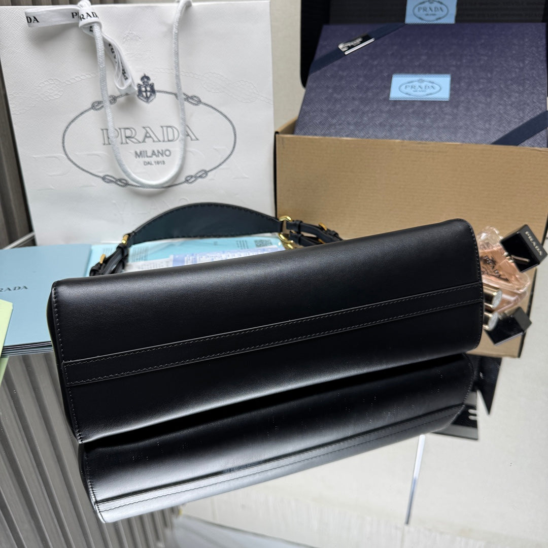 Prada black leather handbag with front seam details and stitched top edge.