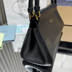 Prada black leather handbag with double top handles and gold-tone hardware.