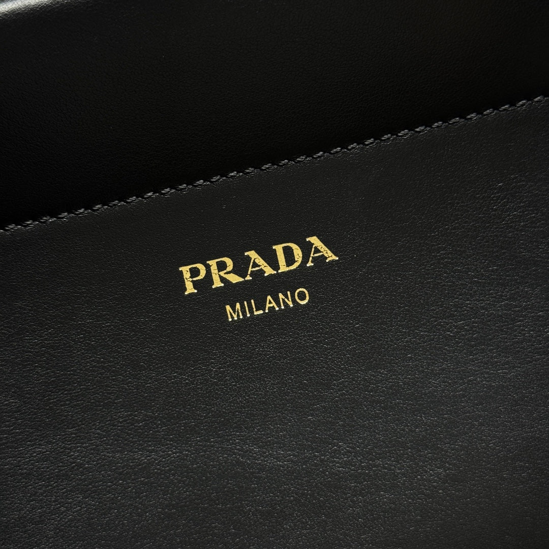 Prada Milano leather logo patch on black bag with contrast topstitching.
