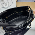 Prada black leather handbag interior with zip pocket and gold-tone zipper.