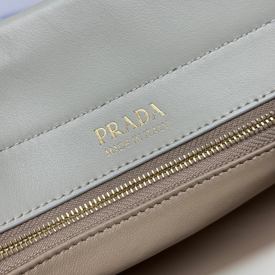 Prada logo and gold zipper on white leather handbag with stitched trim