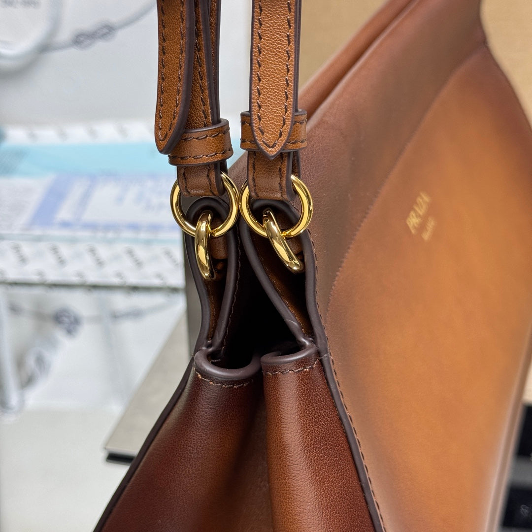 Prada brown leather handbag handle with gold-tone rings and stitched strap ends