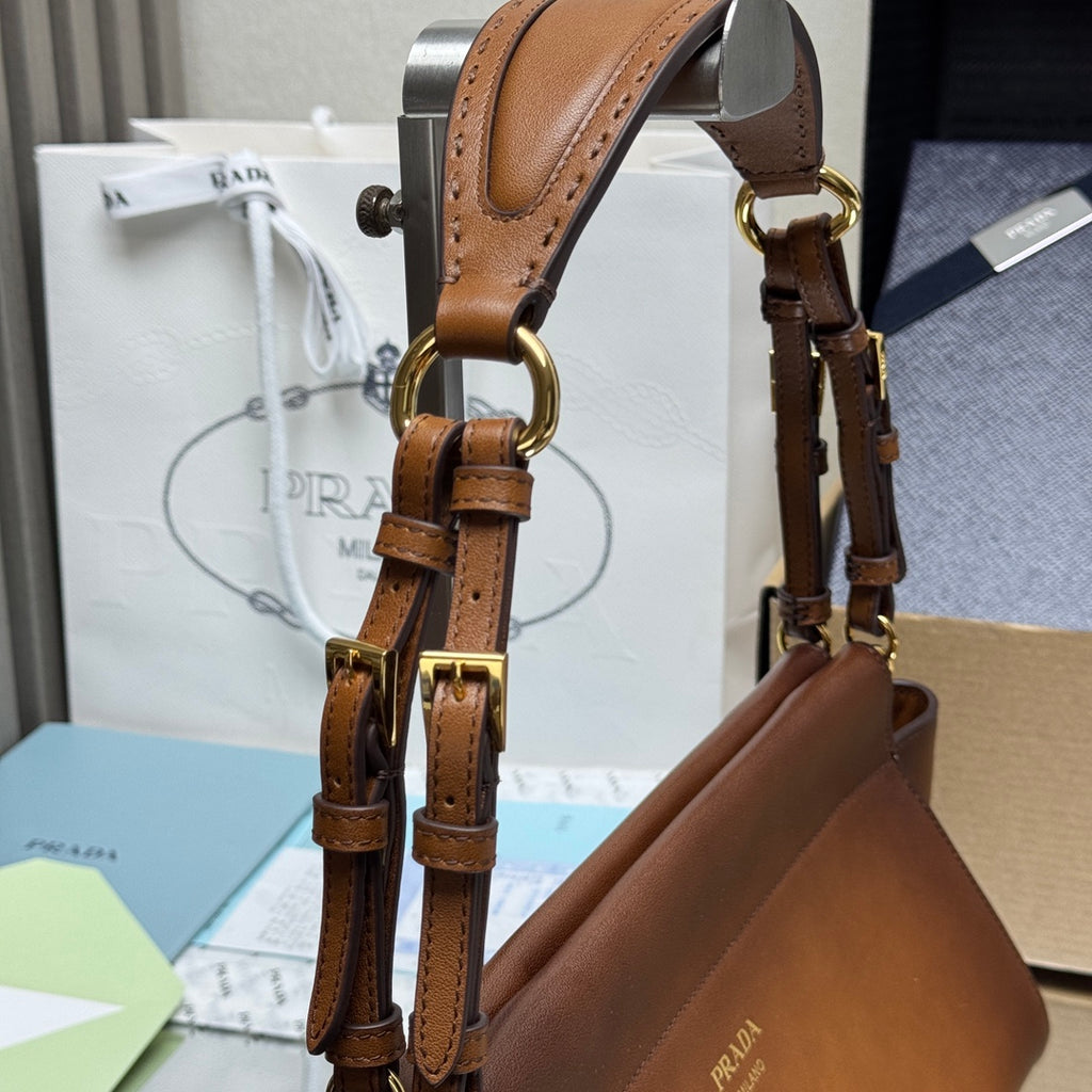 Prada brown leather top-handle bag with gold-tone buckles and chain hardware