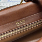 Prada brown leather bag with gold zipper and "Made in Italy" logo