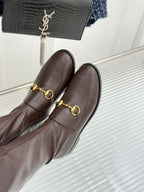Close-up of Gucci ladies knee-high leather boots with gold-tone bit detail