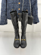 Black leather knee-high boots with gold horsebit straps and pull-tab zips