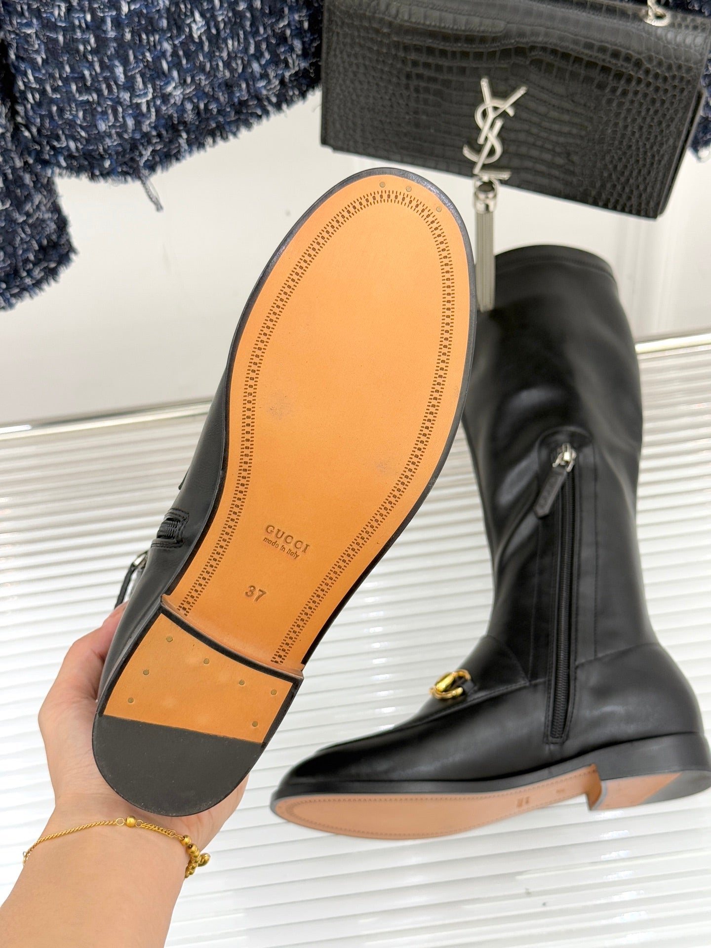 Gucci black leather boot outsole view with gold horsebit pull and side zipper