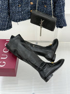 Black leather knee-high boots with gold horsebit detail and side zipper