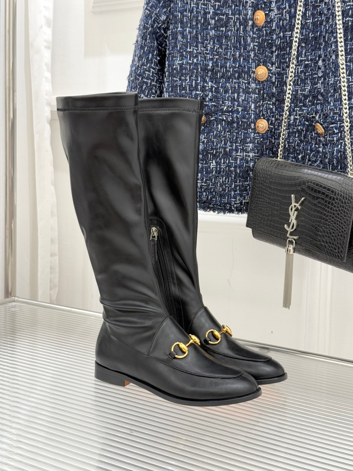 Black leather ankle-high boot with gold horsebit detail and zipper pull