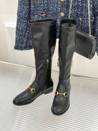 Black leather boots pair with gold horsebit accents and long side zipper detail