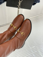 Gucci ladies knee-high leather boots close-up of gold-tone horsebit hardware on vamp