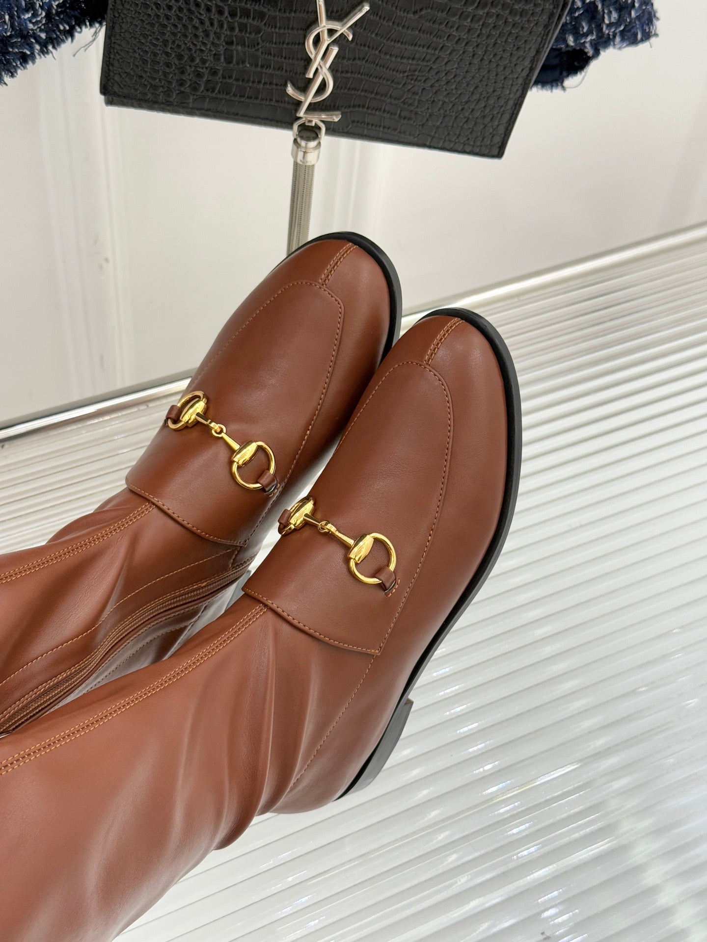 Gucci ladies knee-high leather boots close-up of gold-tone horsebit hardware on vamp
