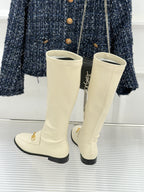 Women's off-white knee-high boots with gold zipper pull and black sole trim
