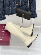 Women's off-white knee-high boots with gold trim and black sole, angled view