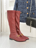Maroon knee-high leather boots with gold horsebit hardware and low block heel