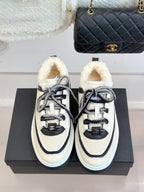 White Chanel sneakers with black panels, rope laces, and plush shearling-style lining