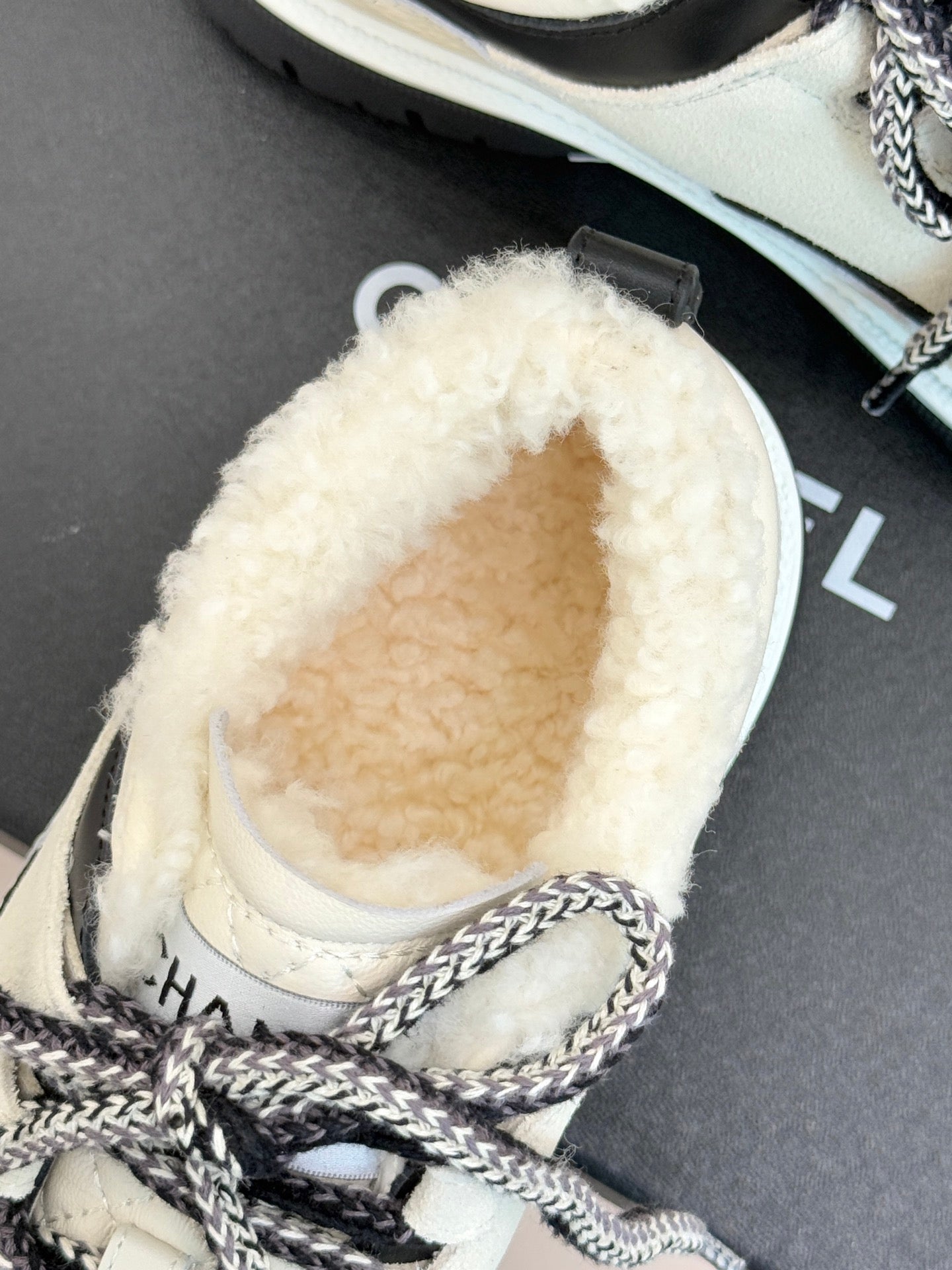 Chanel sneaker close-up with fuzzy white interior and stitched toe panel
