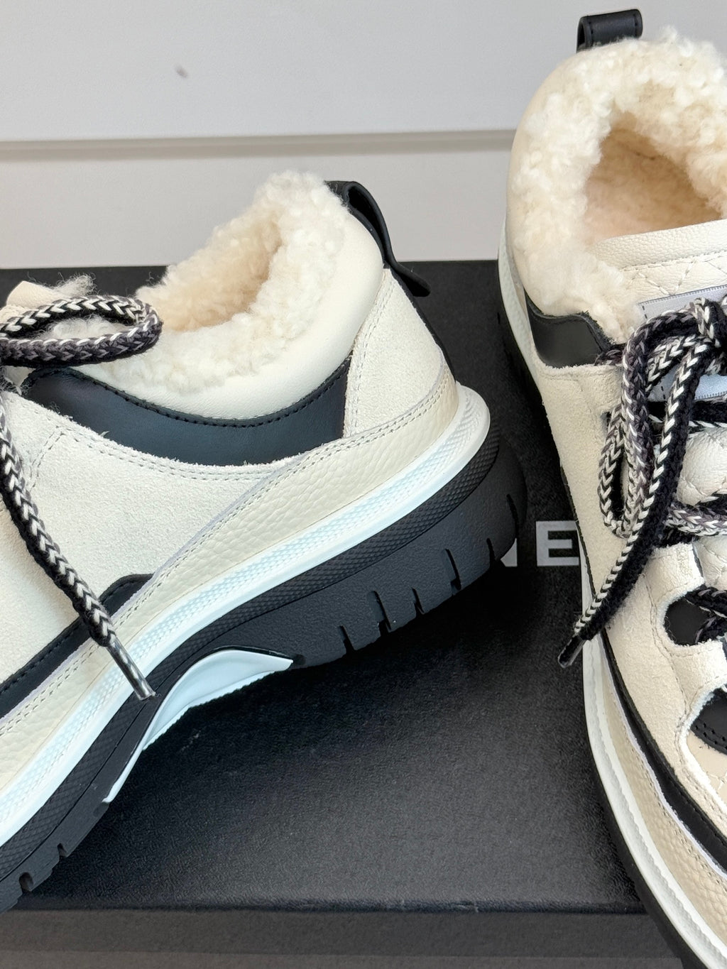 Close-up of white Chanel sneakers with plush interior and thick rubber sole