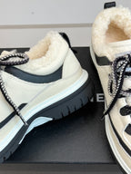 Close-up of white Chanel sneakers with plush interior and thick rubber sole