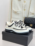 Chanel lace-up sneakers in white with black trim, fleece lining, and chunky sole