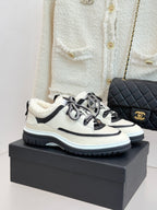 Chanel lace-up sneakers in white with black trim, fleece lining, and chunky sole