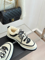 Chanel low-top sneakers in white with black accents and silver-toned lace texture