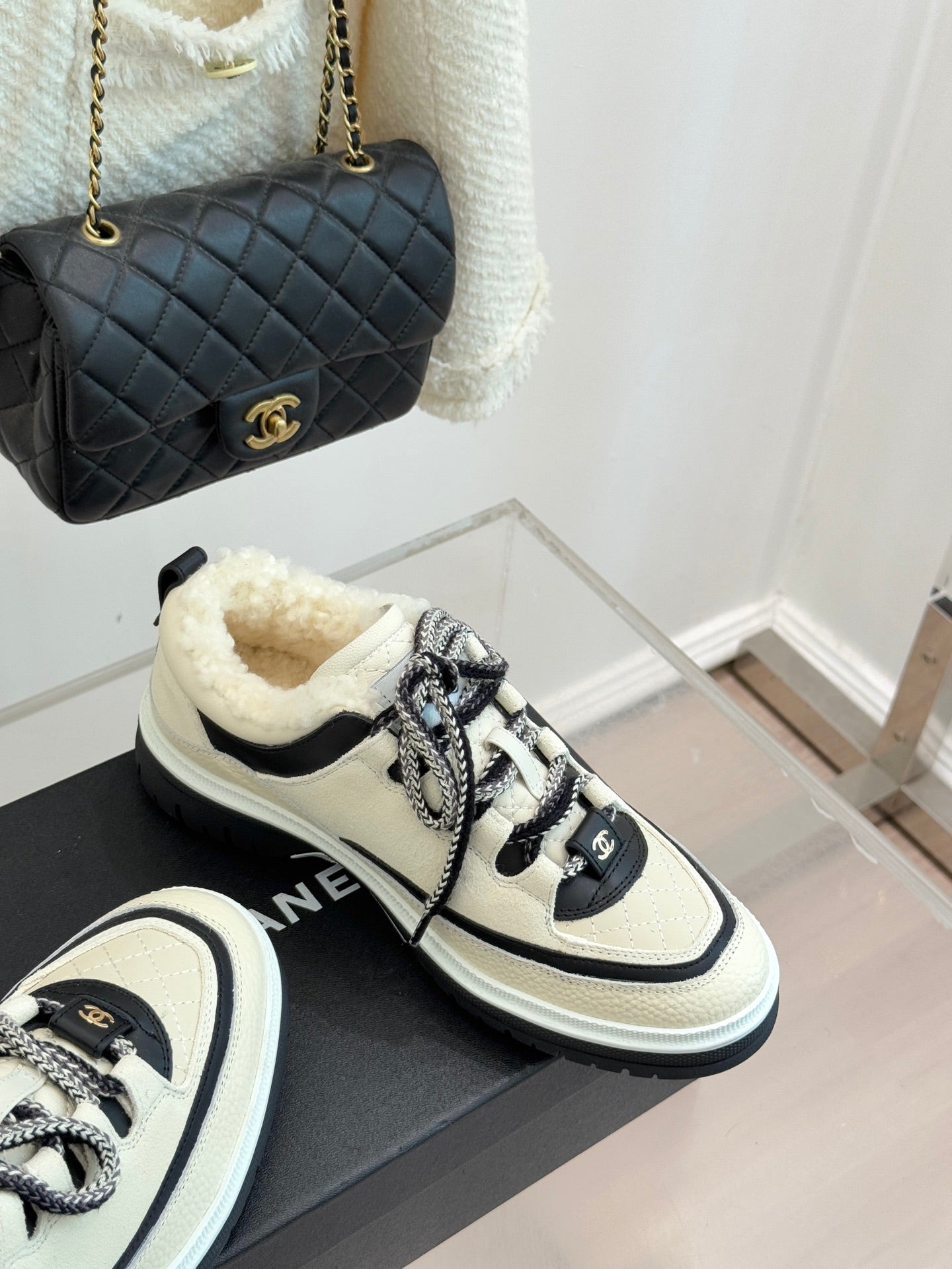 Chanel low-top sneakers in white with black accents and silver-toned lace texture