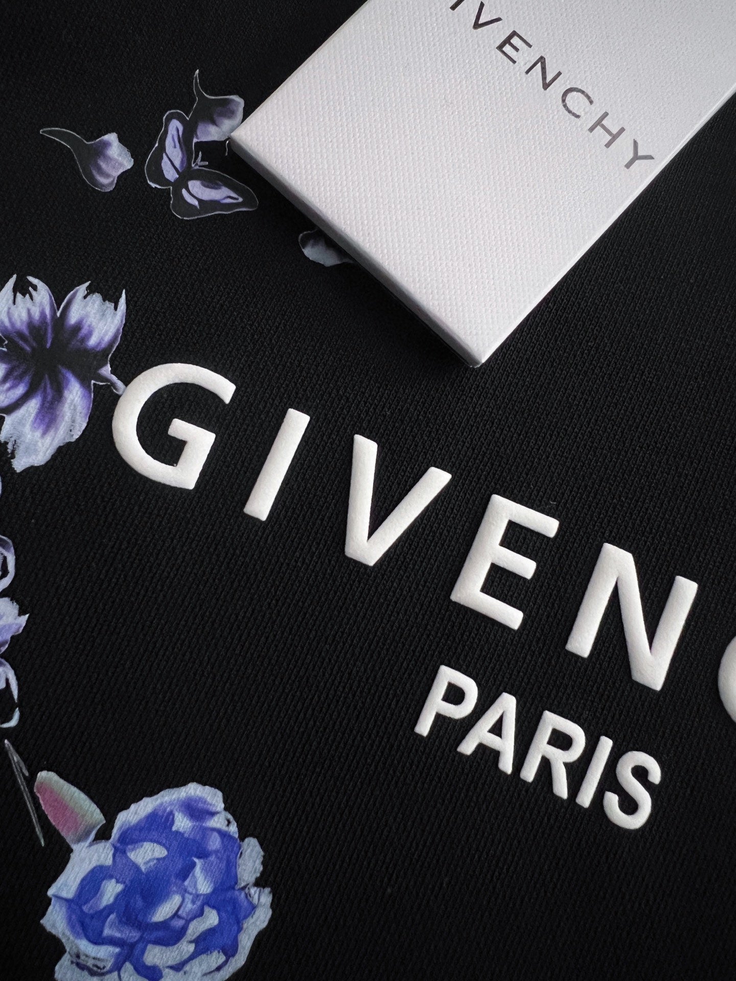 Black sweatshirt fabric with “GIVENCHY PARIS” and blue flower print detail