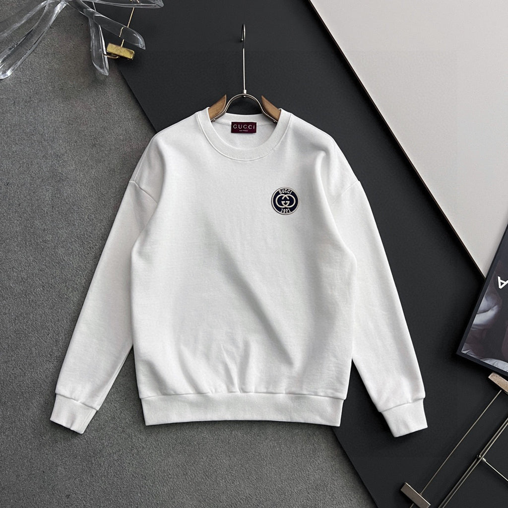 White crewneck sweatshirt with long sleeves and small circular Gucci logo patch