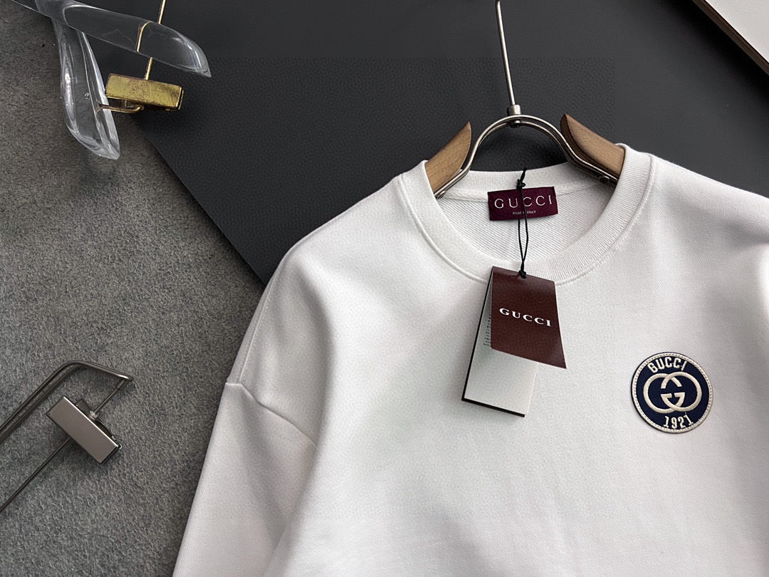 White crewneck sweatshirt detail view, Gucci emblem patch on right chest