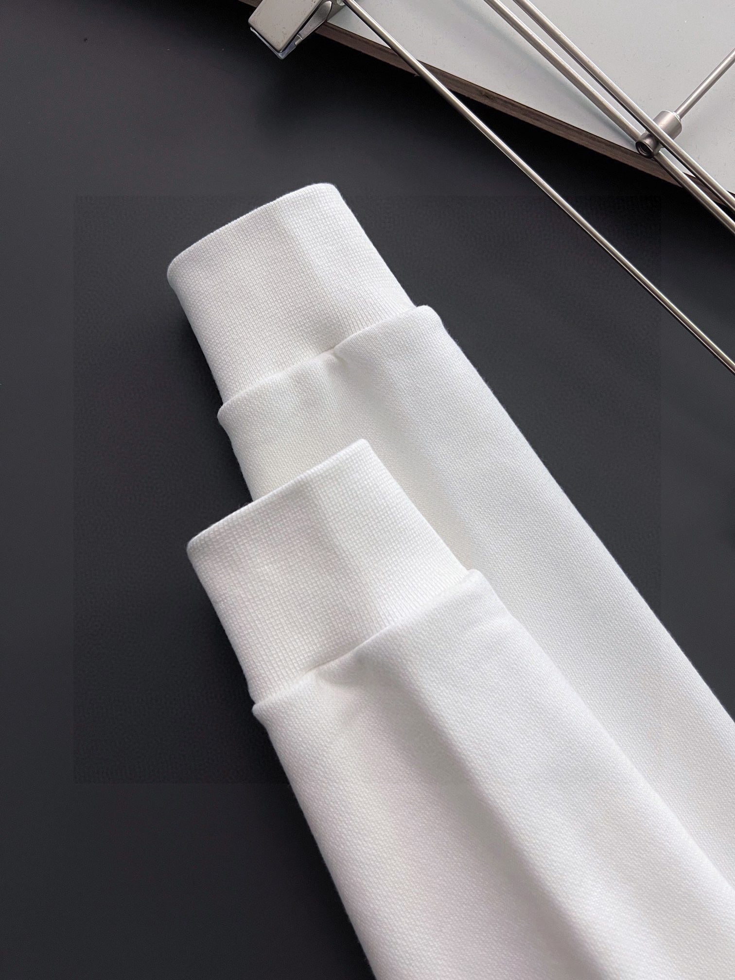 White sweatshirt ribbed cuffs and hem close-up