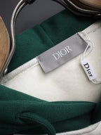 Neckline close-up of Dior two-tone hoodie with green collar and white fabric