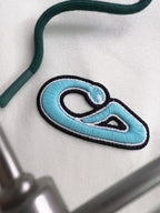 Embroidered blue graphic patch on white fabric of the two-tone hoodie