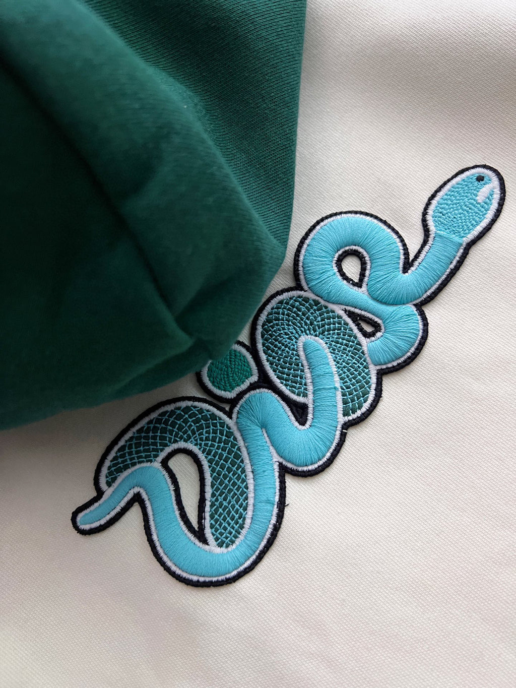 Close-up of blue and black embroidered text-style graphic on hoodie fabric