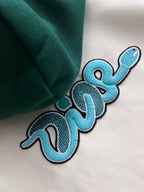 Close-up of blue and black embroidered text-style graphic on hoodie fabric